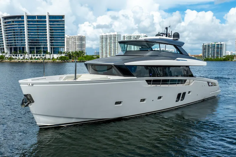  Yacht Photos Pics 2021 Sanlorenzo SX76 yacht cruising near modern city skyline.