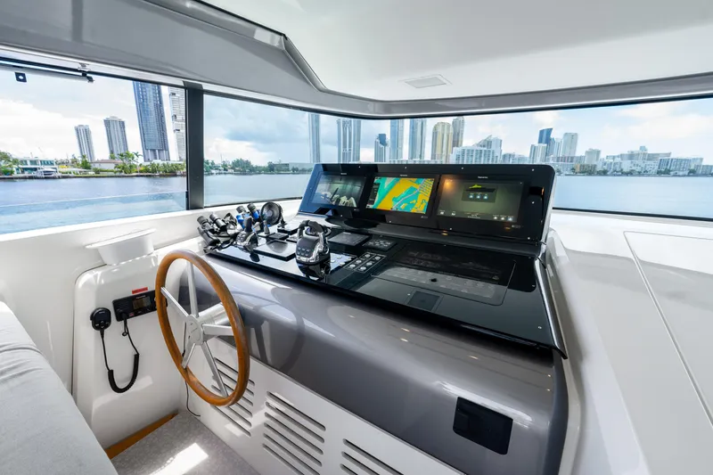  Yacht Photos Pics Helm of 2021 Sanlorenzo SX76 yacht with modern navigation equipment and city skyline view.