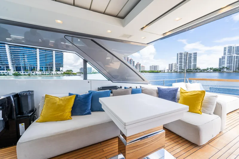  Yacht Photos Pics Luxurious Sanlorenzo SX76 yacht interior with colorful cushions, overlooking a waterfront cityscape.