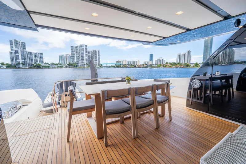  Yacht Photos Pics Outdoor dining area on 2021 Sanlorenzo SX76 yacht with city skyline view.