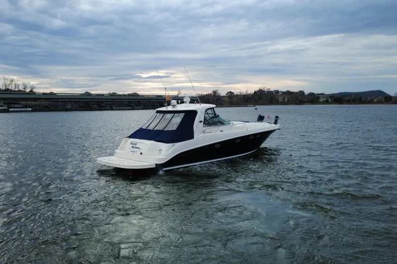  Yacht Photos Pics 2004 Sea Ray Sundancer 460 yacht cruising on a calm lake under cloudy skies.
