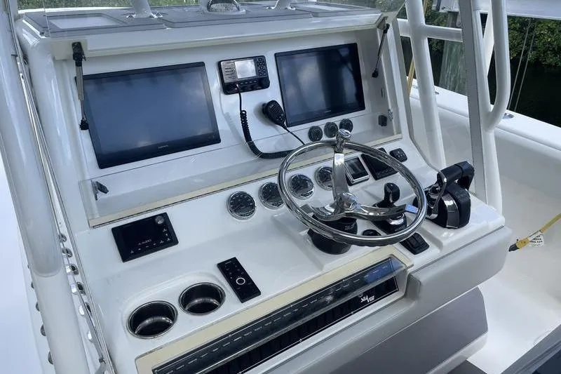  Yacht Photos Pics Control panel of a 2022 SeaVee 370z boat with steering wheel and navigation screens.