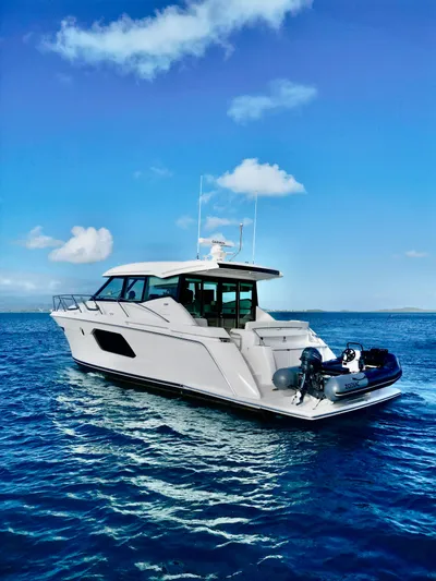  Yacht Photos Pics 2023 Tiara Yachts C49 Coupe cruising on open blue waters under clear skies.
