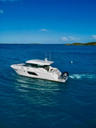  Yacht Photos Pics 2023 Tiara Yachts C49 Coupe cruising on clear blue ocean waters.