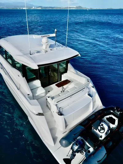  Yacht Photos Pics 2023 Tiara Yachts C49 Coupe on blue ocean waters, rear view.