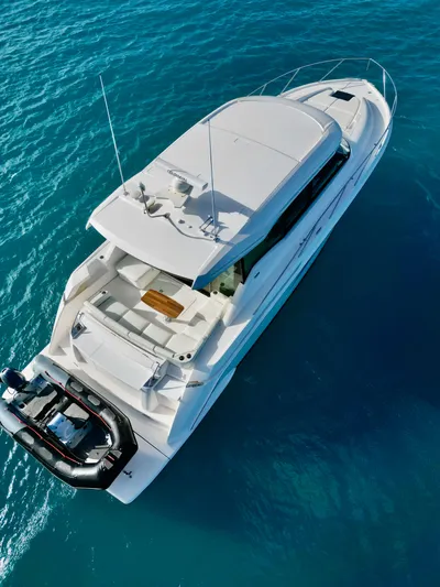  Yacht Photos Pics 2023 Tiara Yachts C49 Coupe on clear blue water, aerial view.