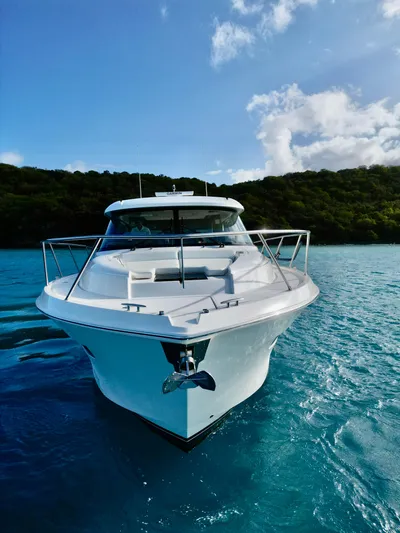  Yacht Photos Pics 2023 Tiara Yachts C49 Coupe on serene blue water, front view.