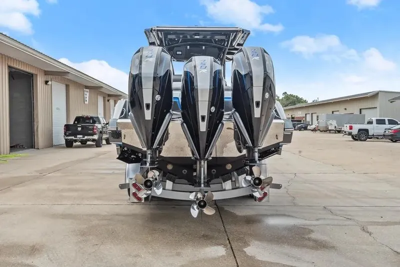  Yacht Photos Pics 2023 Nor-Tech 390 Sport Center Console with triple outboard engines, parked outdoors.