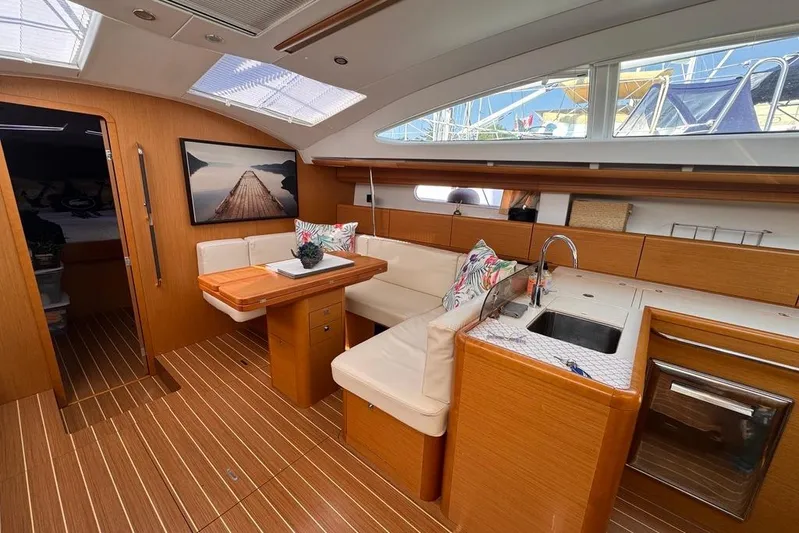  Yacht Photos Pics Luxurious interior of 2011 Jeanneau 50 Deck Saloon with elegant wood finish and modern amenities.