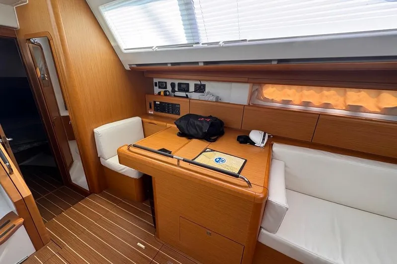 Yacht Photos Pics Interior of 2011 Jeanneau 50 Deck Saloon with wooden finish and seating area.