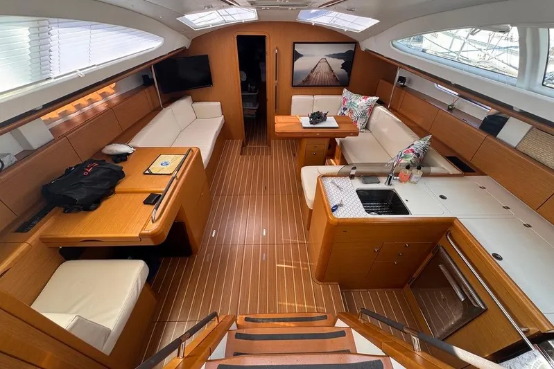  Yacht Photos Pics Luxurious interior of 2011 Jeanneau 50 Deck Saloon with modern furnishings and wood finish.
