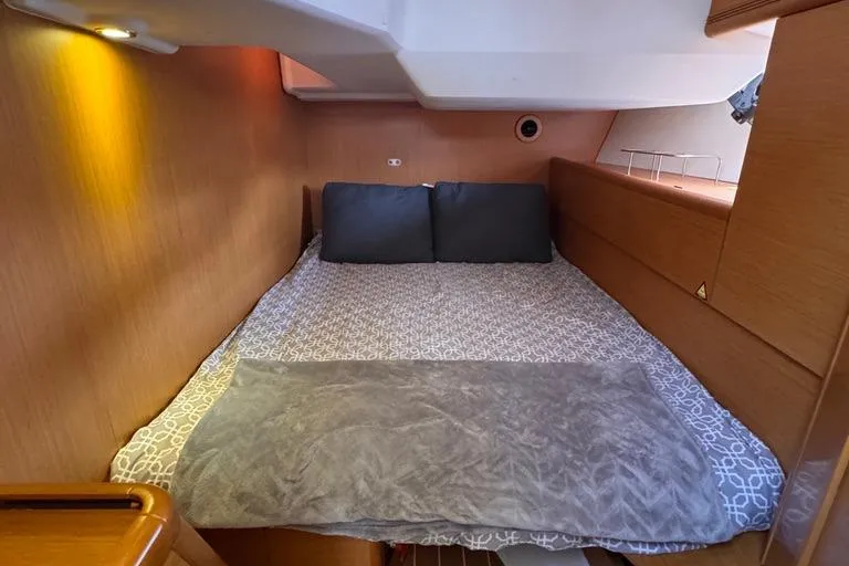  Yacht Photos Pics Cozy cabin interior of 2011 Jeanneau 50 Deck Saloon with comfortable bedding.