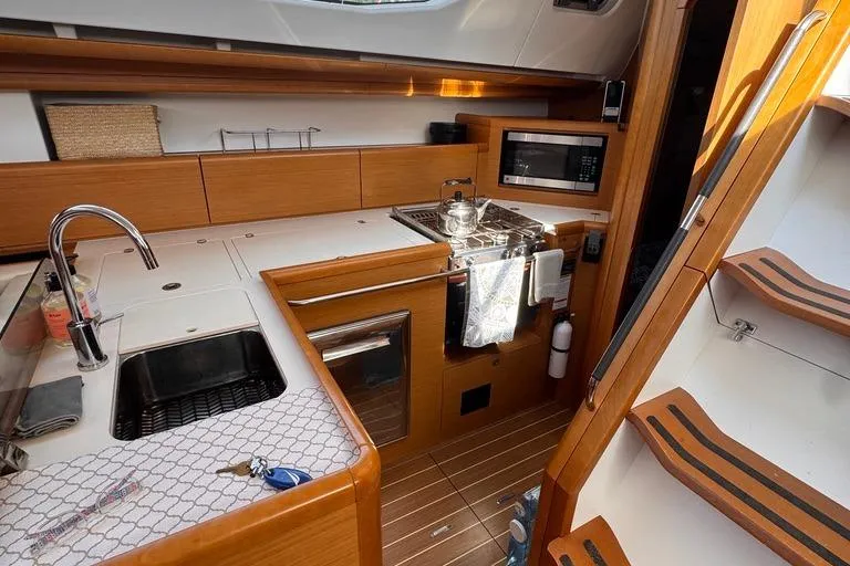  Yacht Photos Pics Modern kitchen in 2011 Jeanneau 50 Deck Saloon yacht with wood finish and appliances.