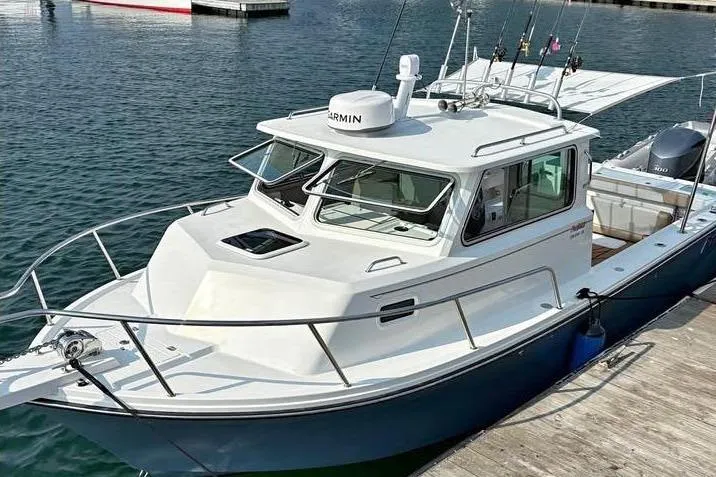  Yacht Photos Pics 2019 Parker 2520 XL Sport Cabin boat docked in calm waters.