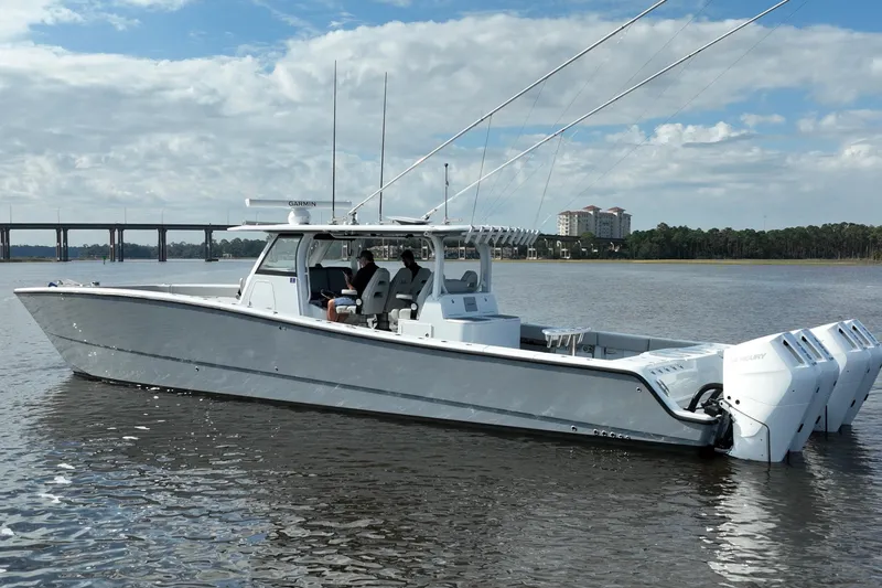  Yacht Photos Pics 2022 Freeman 47 boat on water with multiple outboard engines, bridge in background.