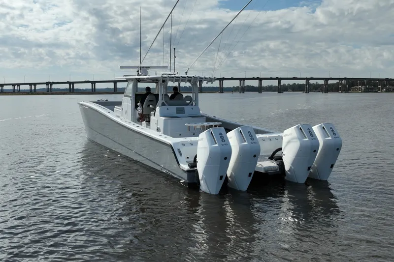  Yacht Photos Pics 2022 Freeman 47 boat with four engines on calm water, bridge in background.