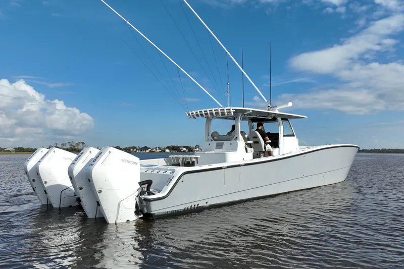  Yacht Photos Pics 2022 Freeman 47 boat with triple Mercury engines on calm water under blue sky.