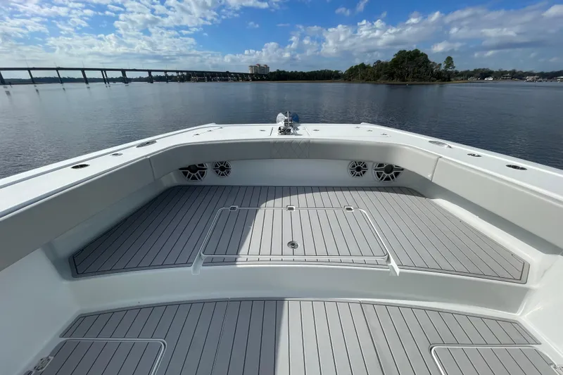  Yacht Photos Pics Freeman 47 boat deck, 2022 model, on calm water with bridge and trees in background.
