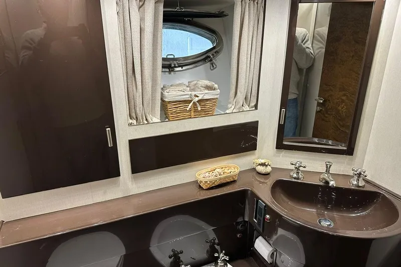  Yacht Photos Pics Bathroom interior of 1990 Riva Corsaro 20 yacht with sink, mirror, and porthole window.