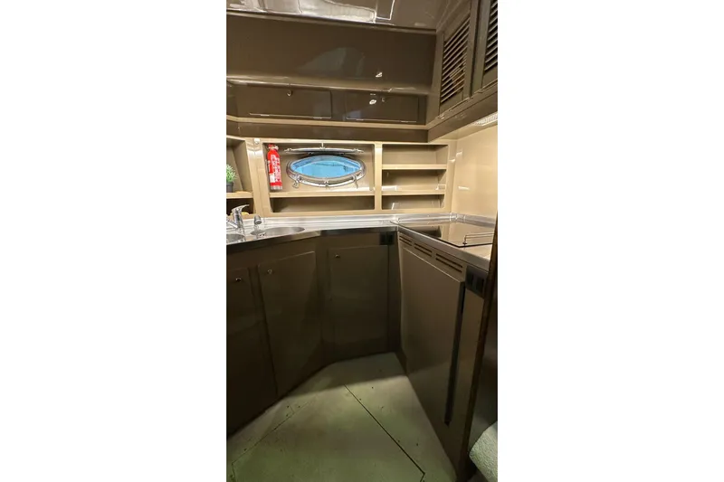  Yacht Photos Pics Interior of 1990 Riva Corsaro 20 yacht kitchen with cabinets and porthole.
