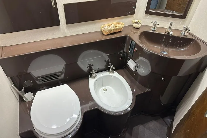  Yacht Photos Pics Luxurious bathroom in 1990 Riva Corsaro 20 yacht with modern fixtures and elegant design.