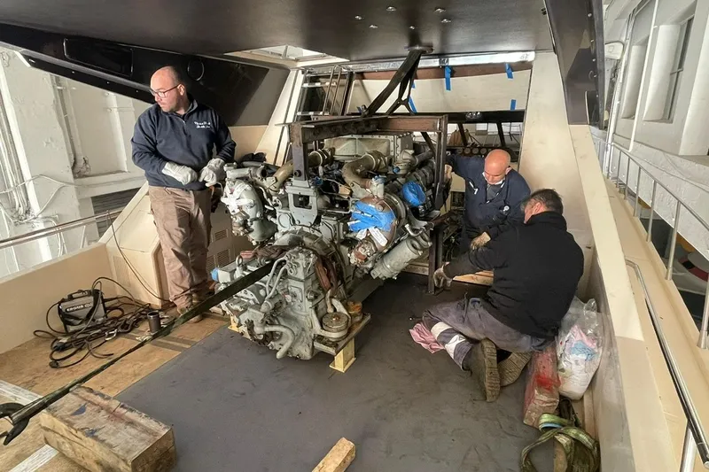  Yacht Photos Pics Mechanics working on a 1990 Riva Corsaro 20 engine in a workshop setting.