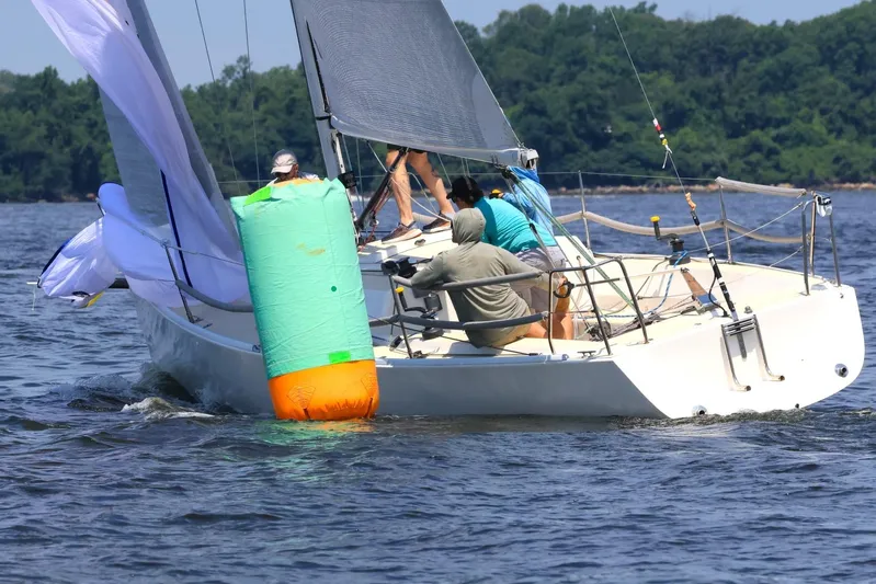  Yacht Photos Pics Sailboat J/100 (2005) navigating near buoy on a sunny day.