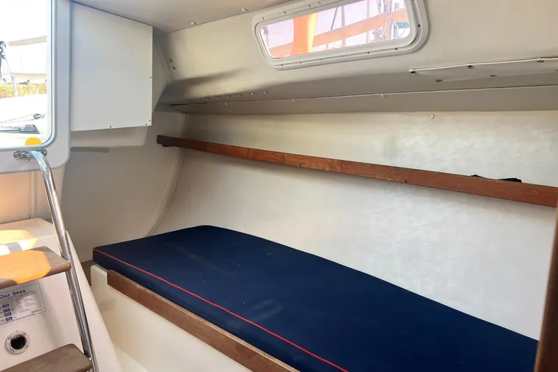  Yacht Photos Pics 2005 J Boats J/100 interior cabin with blue cushion and wooden accents.