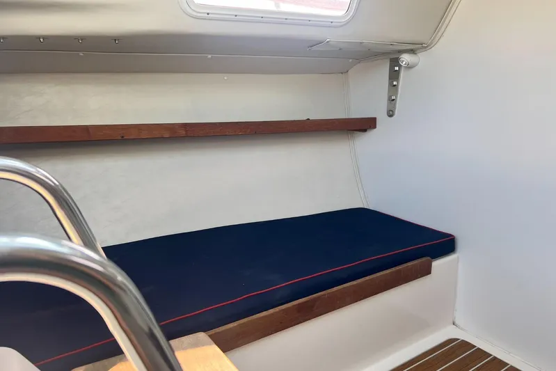  Yacht Photos Pics Interior of 2005 J Boats J/100 sailboat with blue cushioned seating and wooden accents.