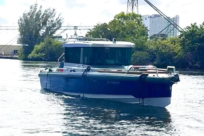  Yacht Photos Pics 2019 Axopar 28 Cabin boat cruising on a calm waterway.