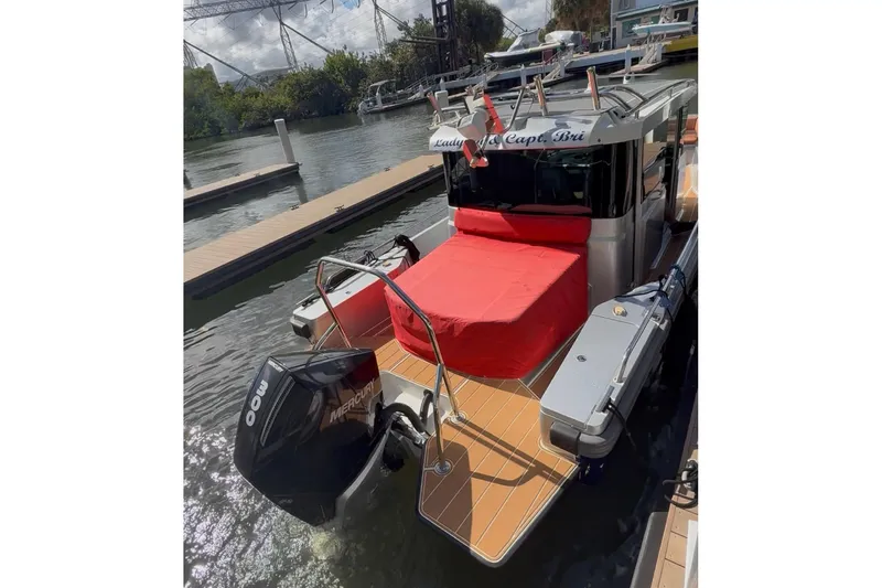  Yacht Photos Pics 2019 Axopar 28 Cabin boat docked, featuring a red cover and Mercury outboard motor.