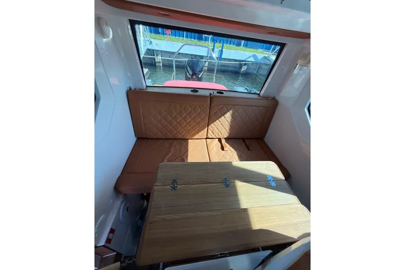  Yacht Photos Pics 2019 Axopar 28 Cabin interior with brown seating and wooden table.