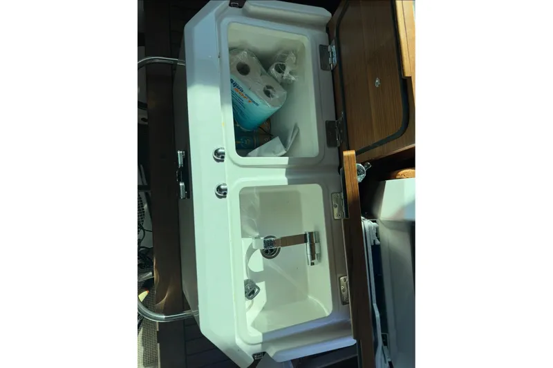  Yacht Photos Pics 2019 Axopar 28 Cabin sink with storage, featuring paper towels and cleaning supplies.