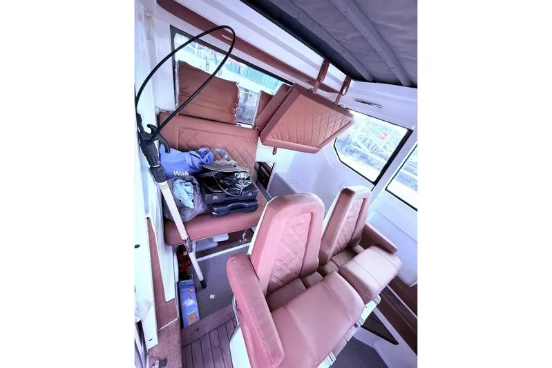  Yacht Photos Pics 2019 Axopar 28 Cabin interior with tan leather seats and storage items.