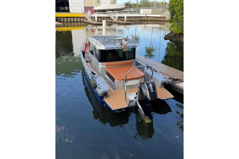  Yacht Photos Pics 2019 Axopar 28 Cabin boat docked in a calm marina setting.