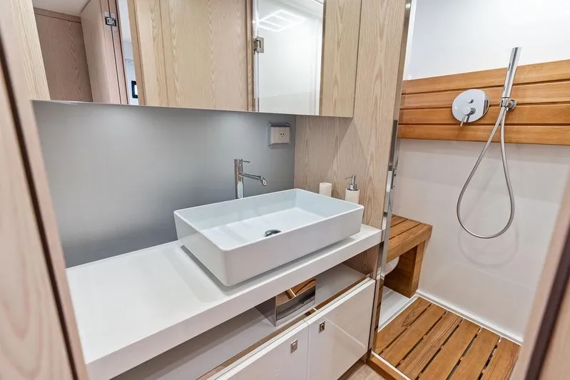 Yacht Photos Pics Modern bathroom in 2026 SACS Rebel 55 yacht with sleek sink and wooden shower accents.