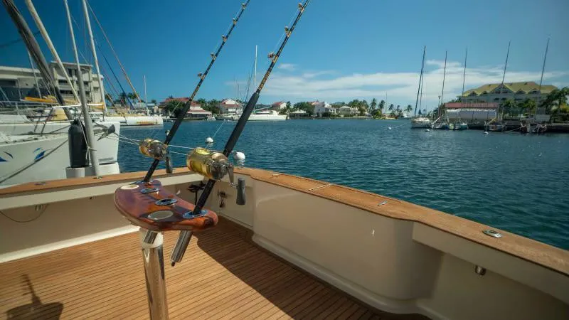 Sea Ghost Yacht Photos Pics 2008 Spencer Custom Carolina Express boat with fishing rods, docked in a sunny marina.