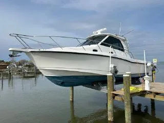  Yacht Photos Pics 2008 Boston Whaler 345 Conquest boat docked on a lift by the water.