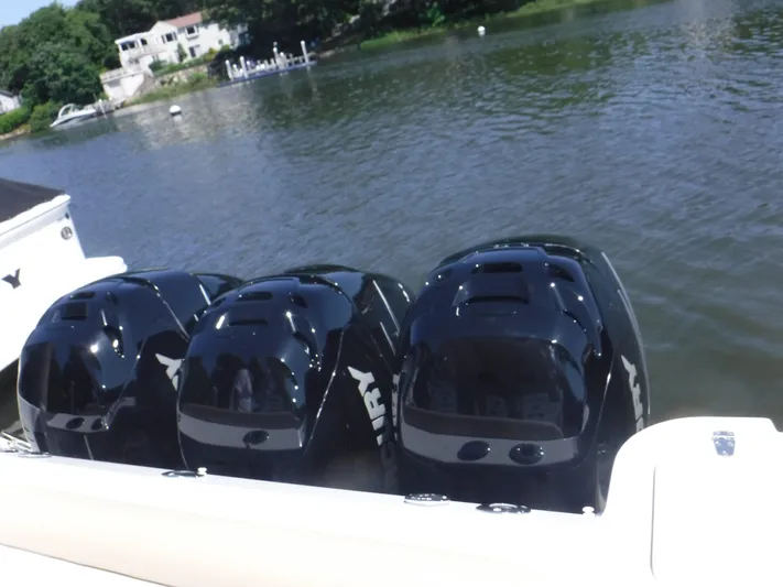  Yacht Photos Pics Triple Mercury outboard engines on a 2008 Boston Whaler 345 Conquest, docked by a serene river.