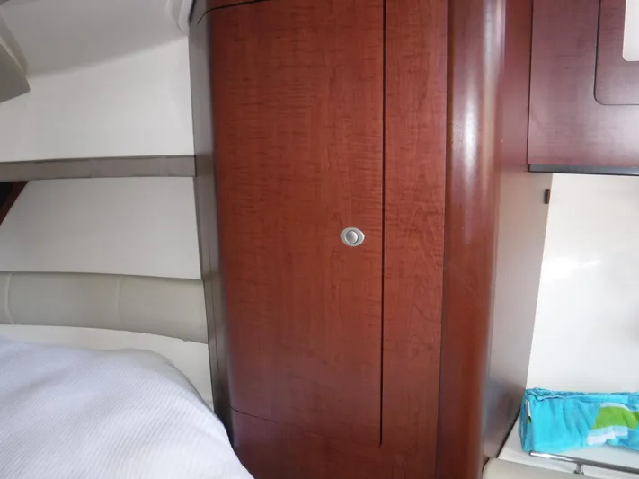  Yacht Photos Pics 2008 Boston Whaler 345 Conquest interior with wooden cabinet and cozy bedding.