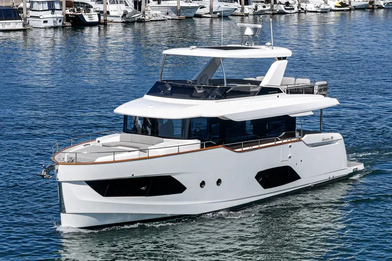  Yacht Photos Pics 2024 Absolute 58 Navetta yacht cruising in a marina, showcasing sleek design and luxury features.