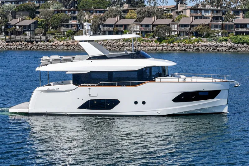  Yacht Photos Pics 2024 Absolute 58 Navetta yacht cruising on a serene waterway near residential area.