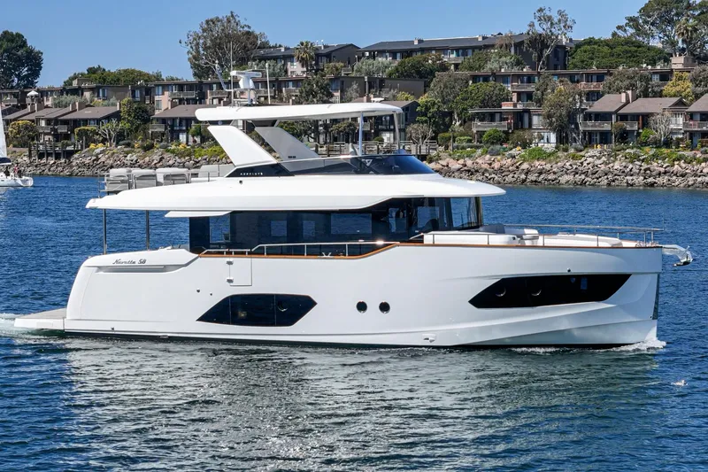  Yacht Photos Pics 2024 Absolute 58 Navetta yacht cruising on a serene waterway near residential area.