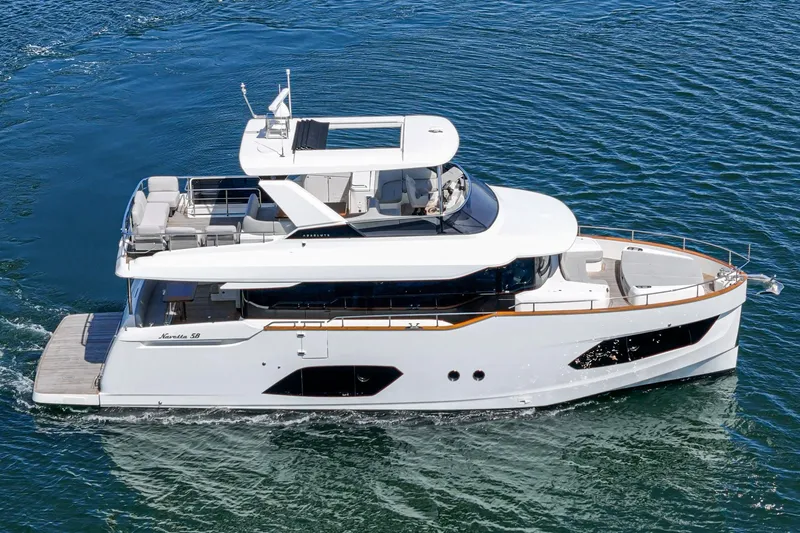  Yacht Photos Pics 2024 Absolute 58 Navetta yacht cruising on blue water, showcasing sleek design and luxury features.