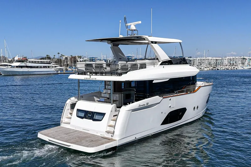  Yacht Photos Pics 2024 Absolute 58 Navetta yacht cruising in a marina, showcasing sleek design and luxury features.