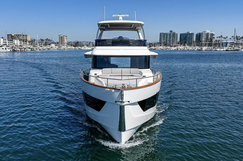  Yacht Photos Pics 2024 Absolute 58 Navetta yacht cruising in a marina with city skyline backdrop.