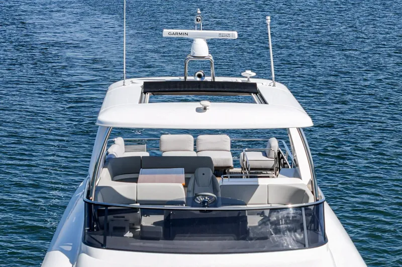  Yacht Photos Pics 2024 Absolute 58 Navetta yacht on calm blue water, showcasing upper deck seating.