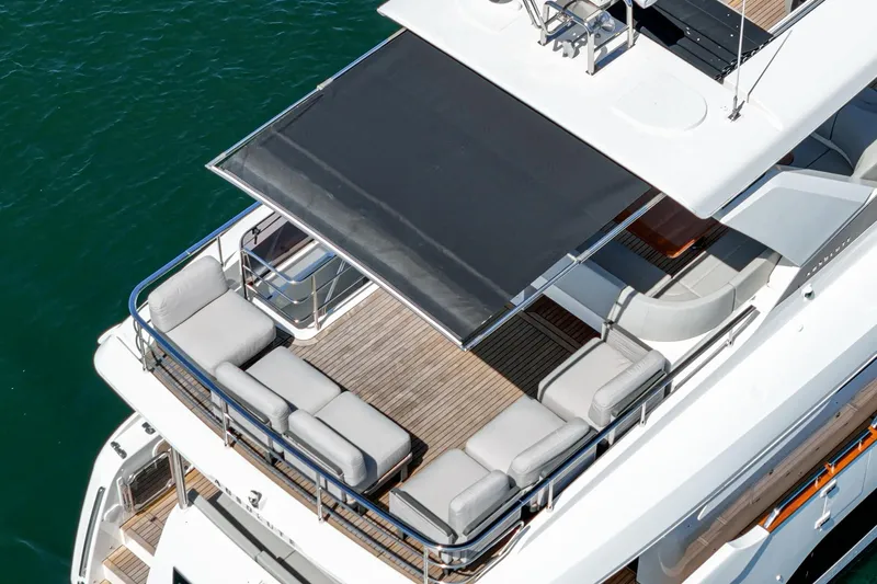  Yacht Photos Pics 2024 Absolute 58 Navetta yacht with spacious deck and seating area, featuring a retractable sunshade.