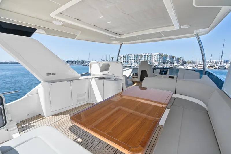  Yacht Photos Pics Luxurious 2024 Absolute 58 Navetta yacht interior with elegant seating and wooden table.