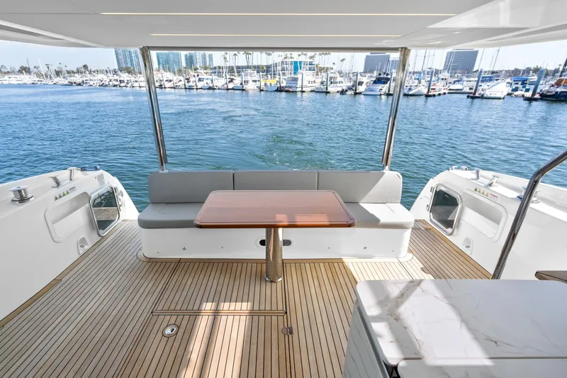  Yacht Photos Pics 2024 Absolute 58 Navetta yacht deck with seating, table, and marina view.